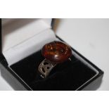 An adjustable 925 and amber coloured ring