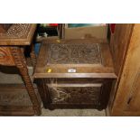 An oak storage box with carved panels and contents