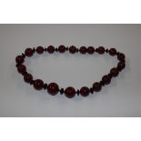 A boxed cherry amber coloured necklace