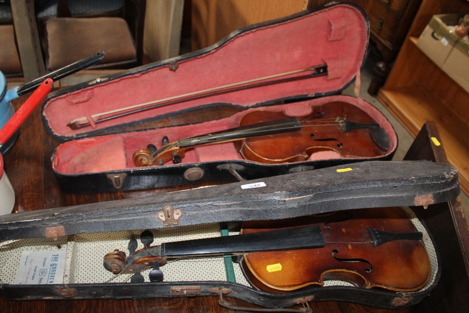 A cased violin and bow with another cased violin A