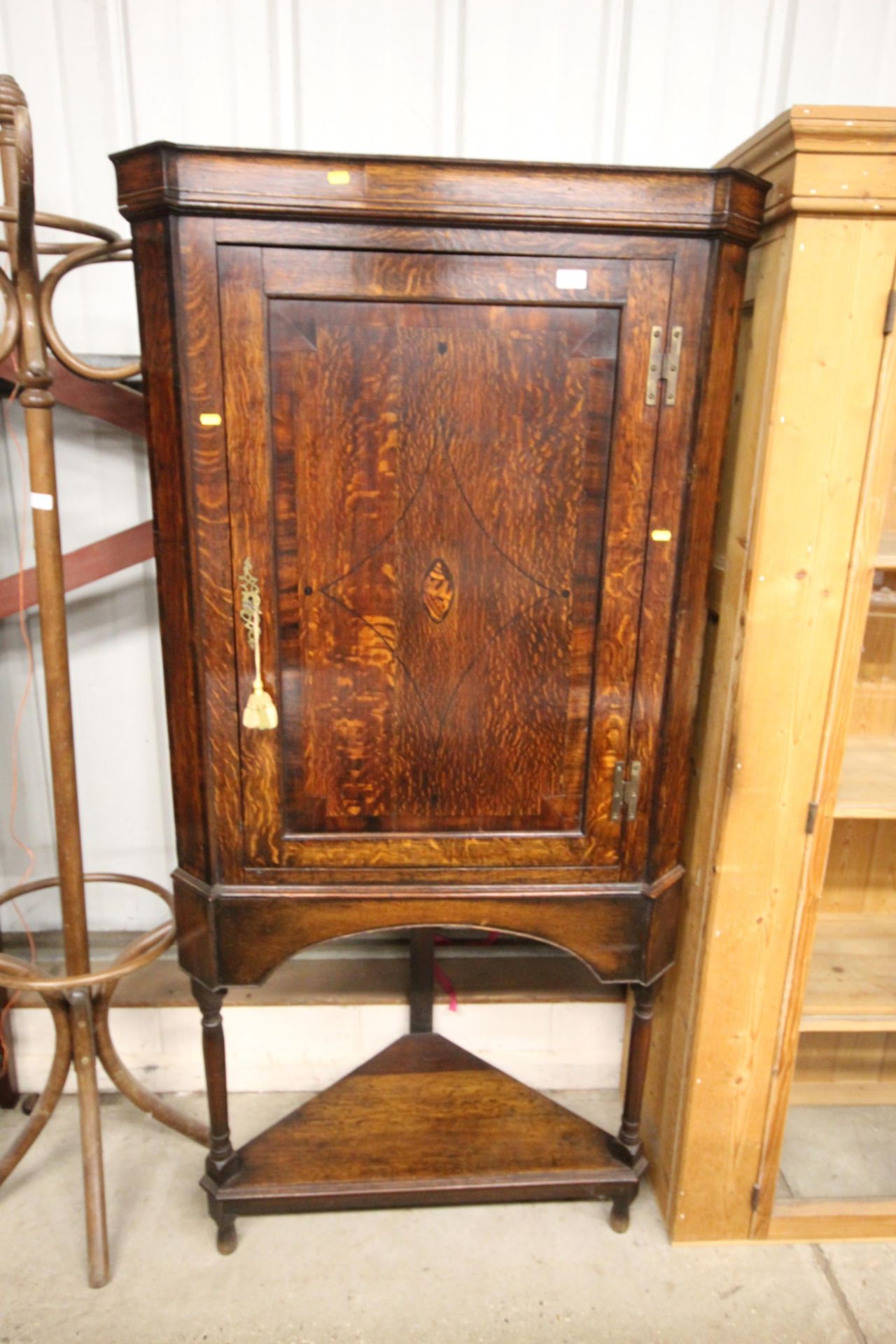 A Georgian oak corner cupboard on stand, the inter