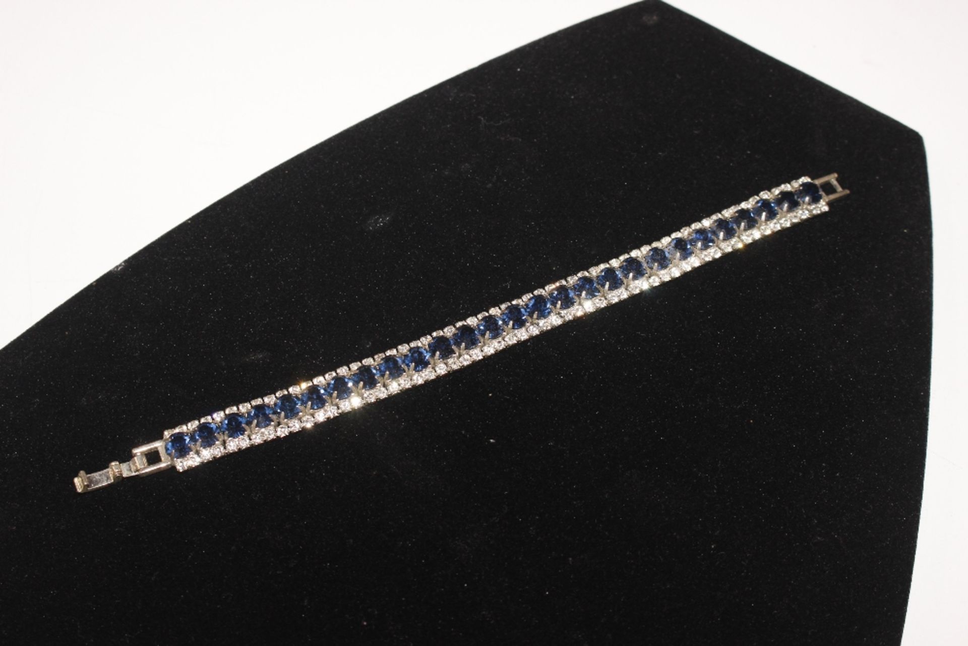 A white metal bracelet set with blue and white sto