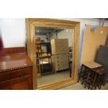 A gilt framed bevelled edge wall mirror