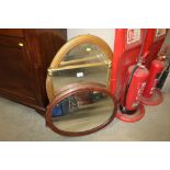 A bevelled edge oval framed wall mirror together w