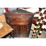 An antique oak corner cupboard