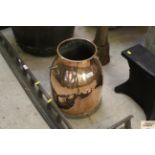 A copper milk churn with swing handle