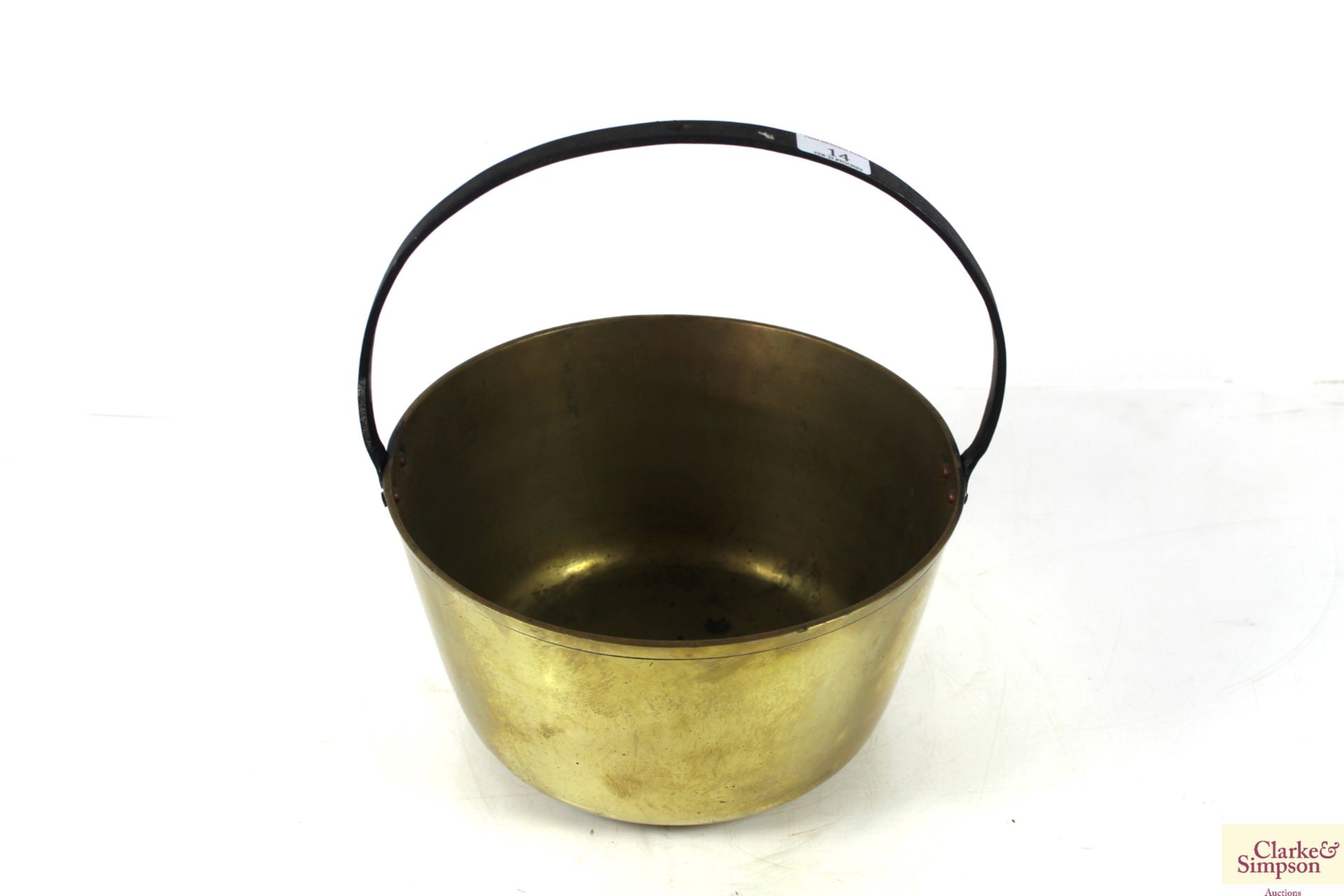 A brass jam pan with metal loop handle