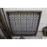 An ornate metal wooden surrounded window cover, ap