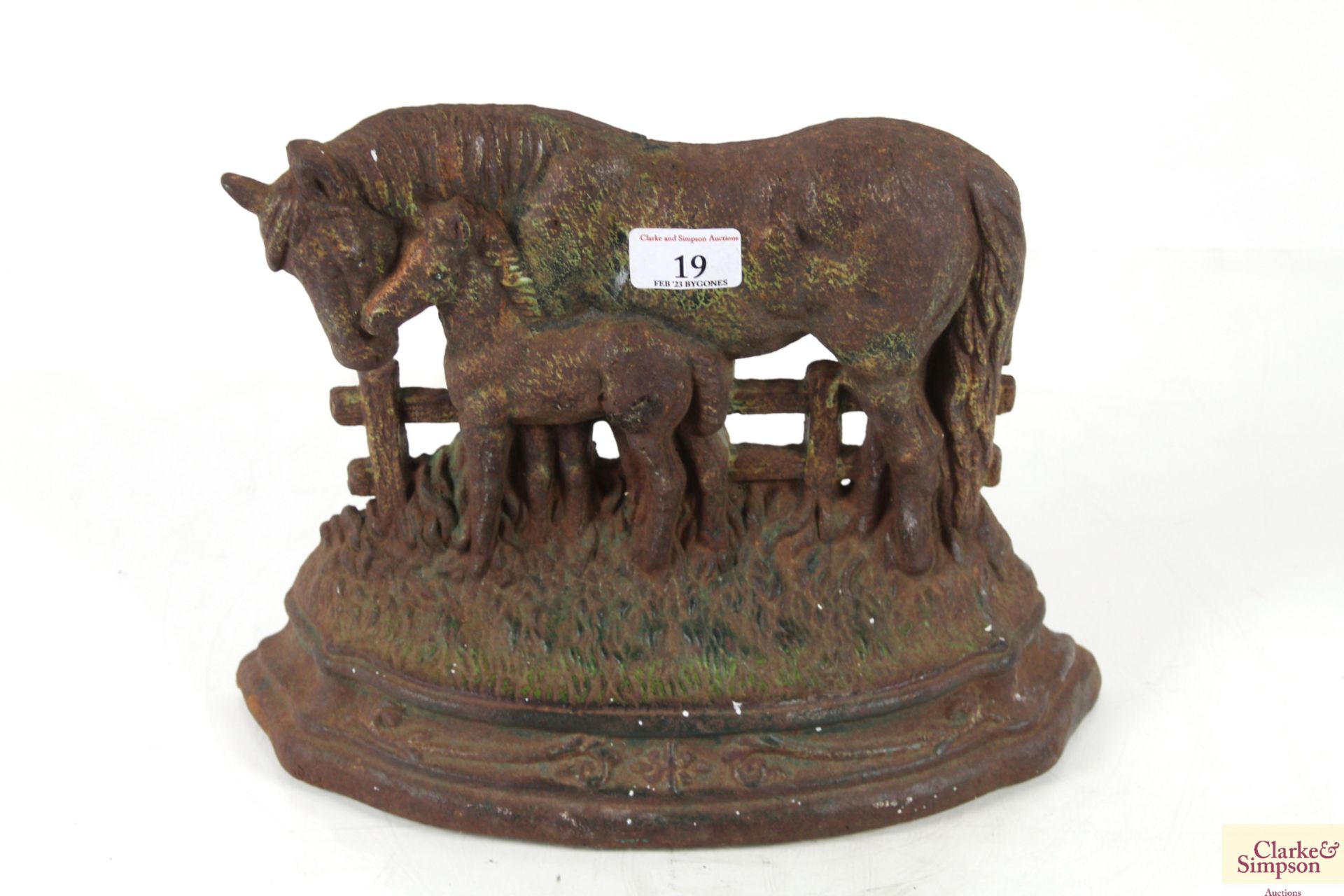 A cast iron doorstop in the form of a horse and fo