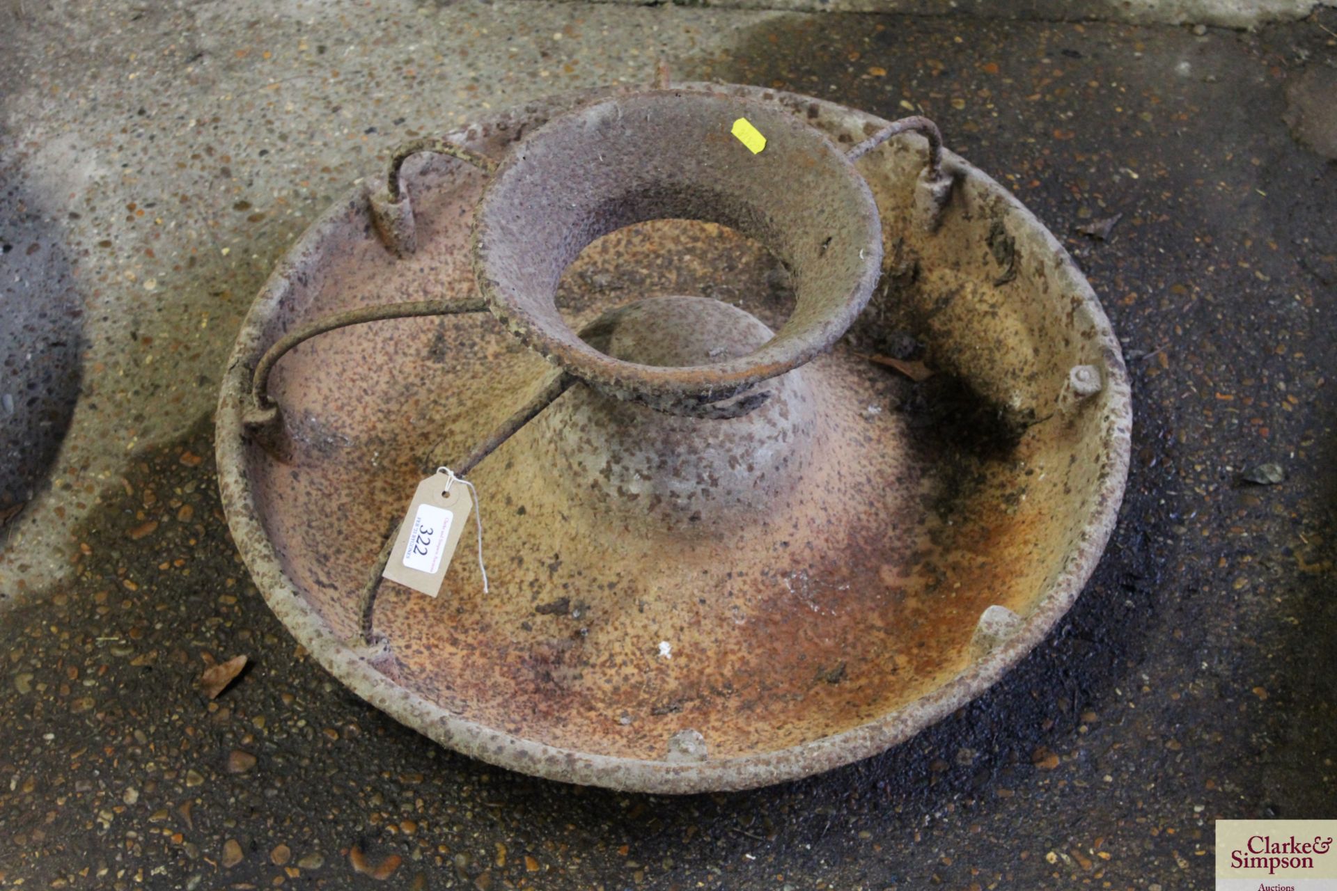 A circular cast iron pig trough with some sections