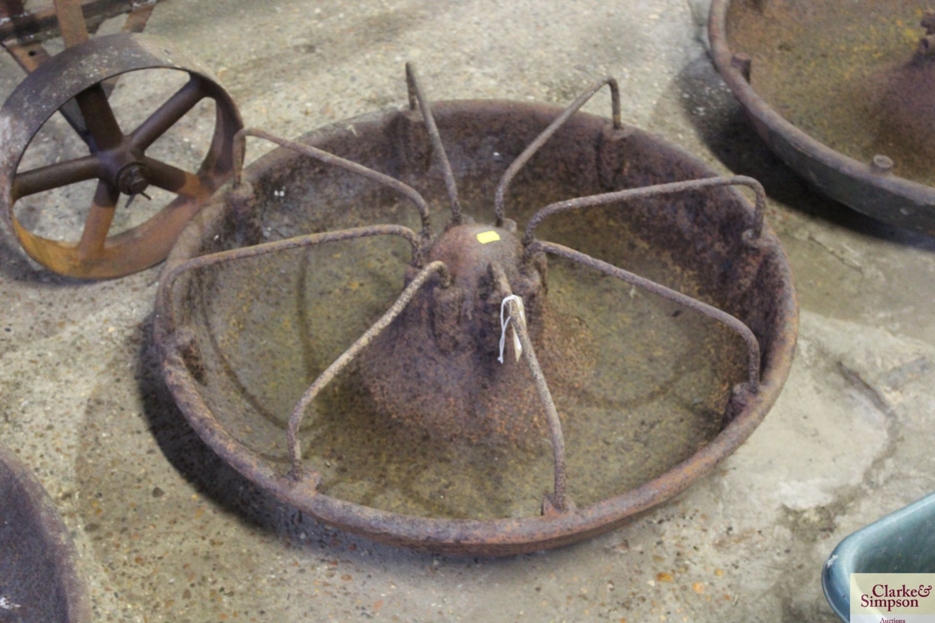 A circular cast iron pig trough with divisions