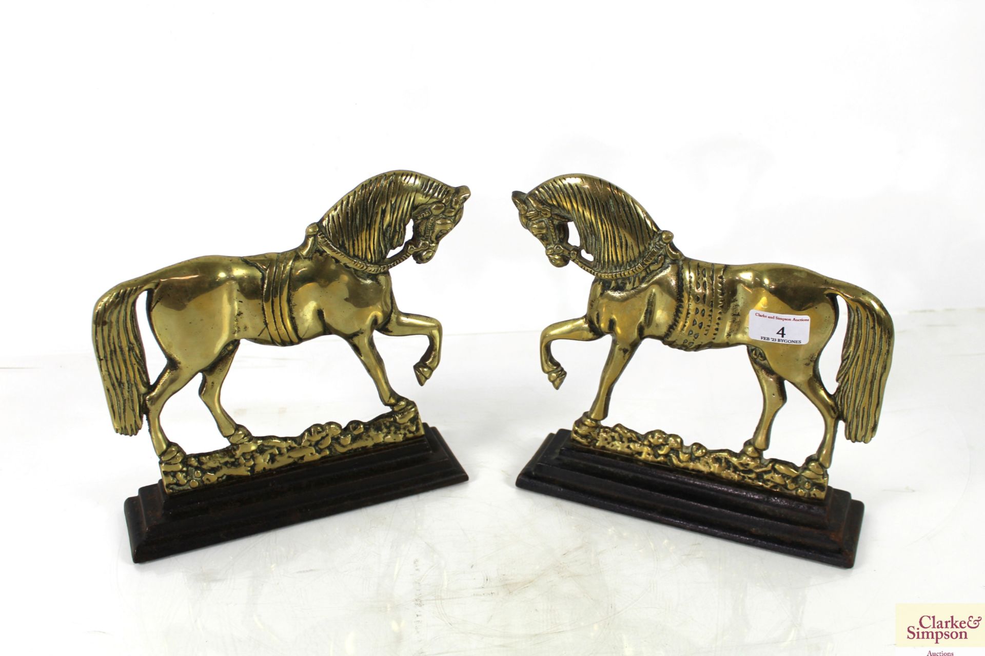 A pair of brass horse doorstops on cast iron bases