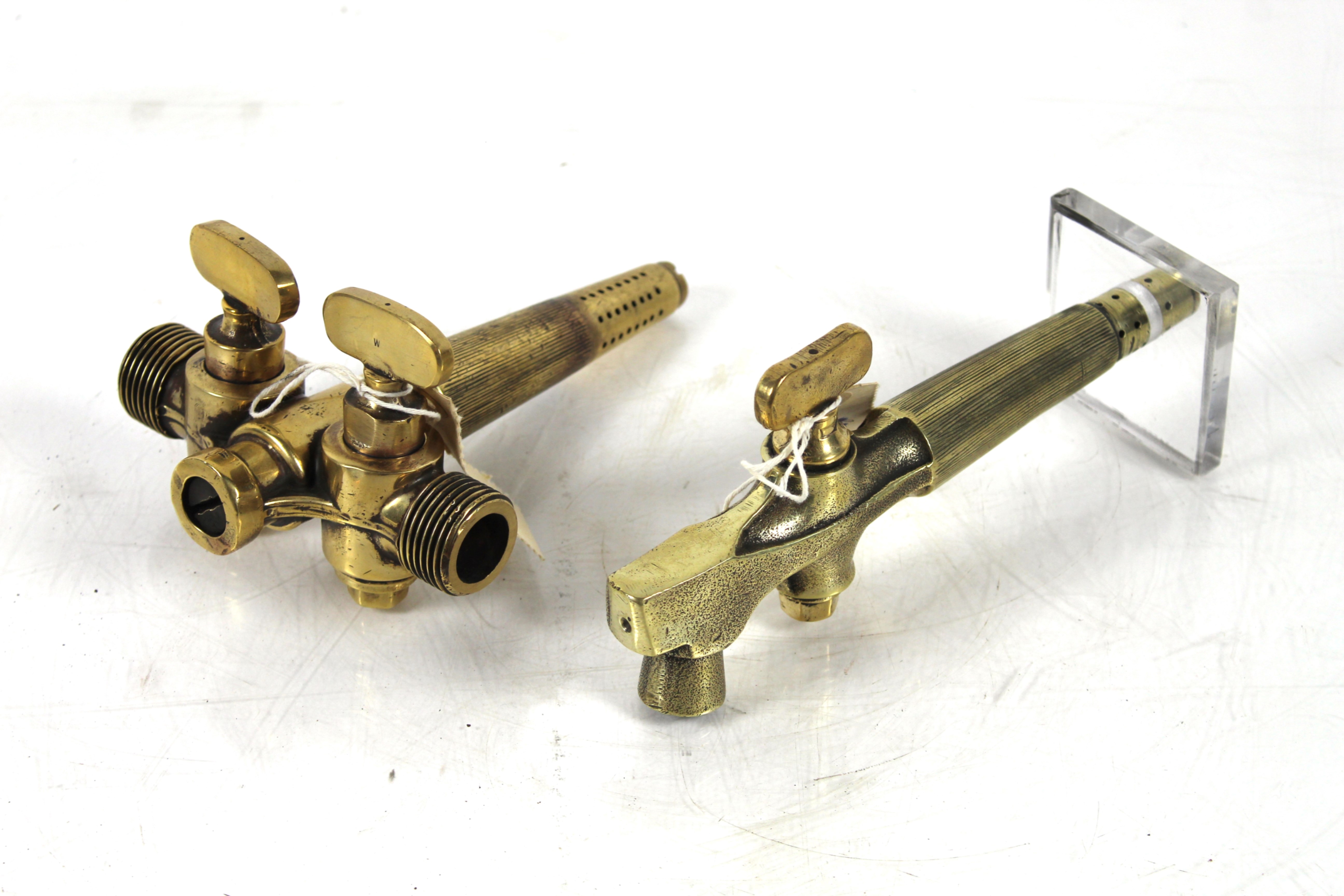 Two large brass beer barrel taps, one with a doubl