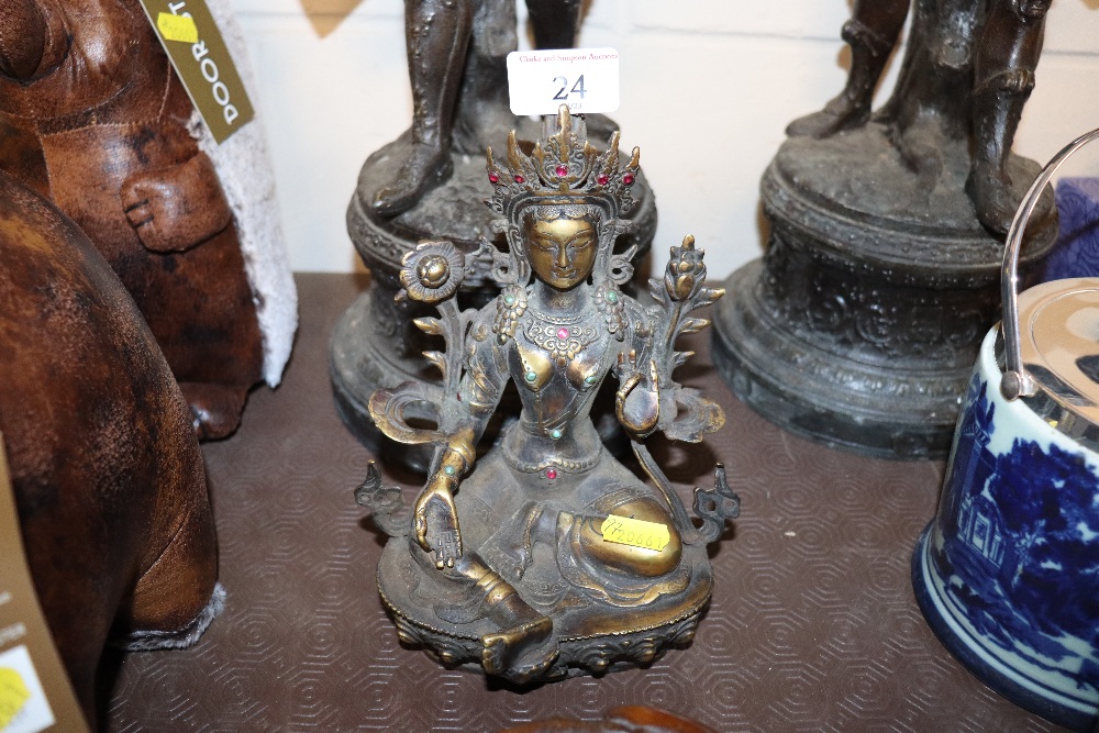 A bronzed deity decorated with coloured stones