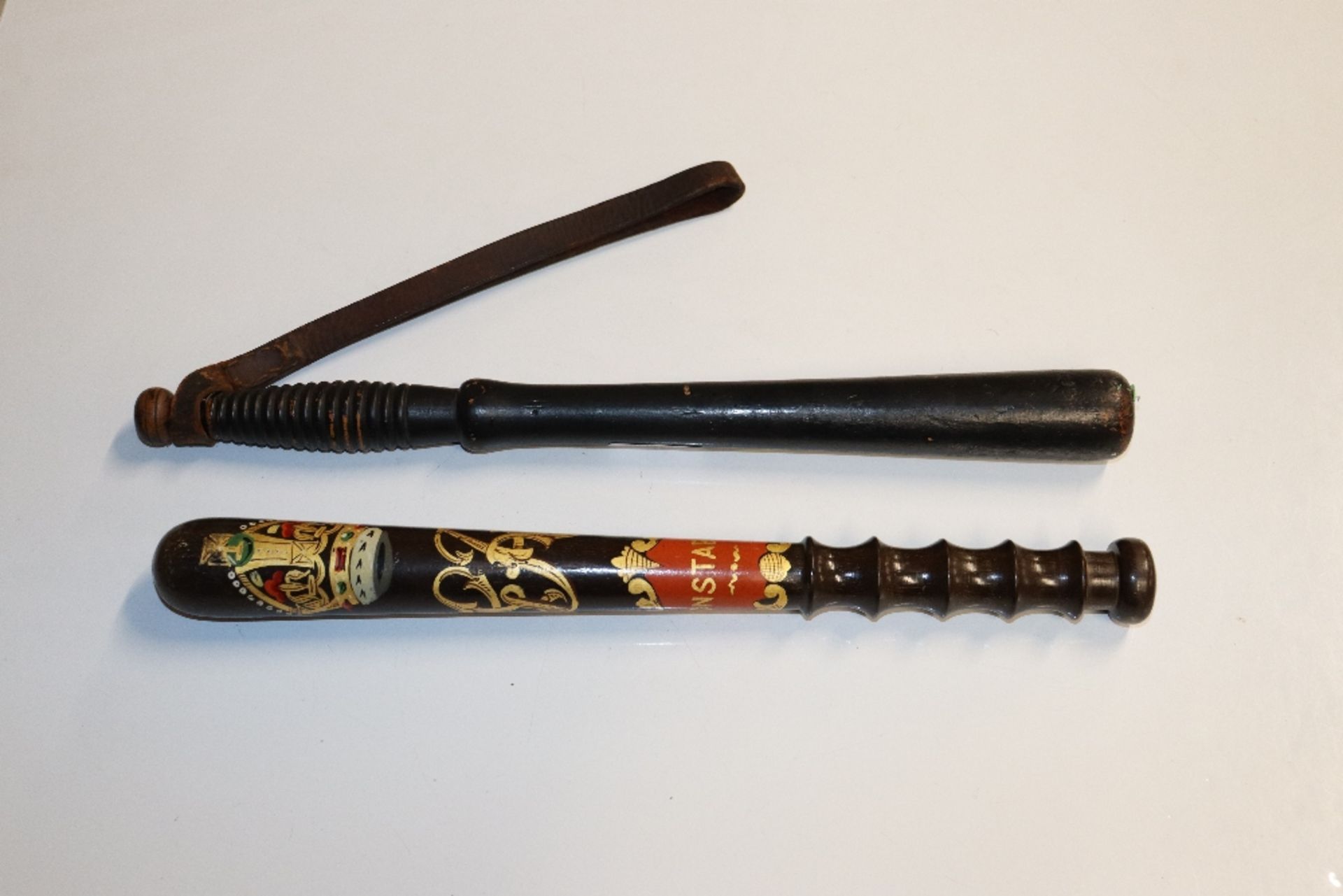 Two wooden truncheons, one with painted decoration