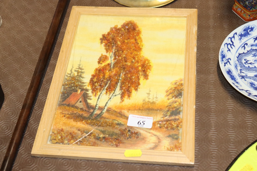 A framed picture of a river scene decorated with orange coloured stones