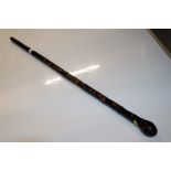 A Japanese lacquered walking stick with carved dec