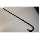 An ebonised walking stick with swan head handle an