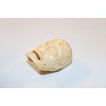 A carved bone ornament in the form of face and sku