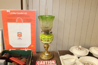 A Victorian oil lamp with green glass reservoir an