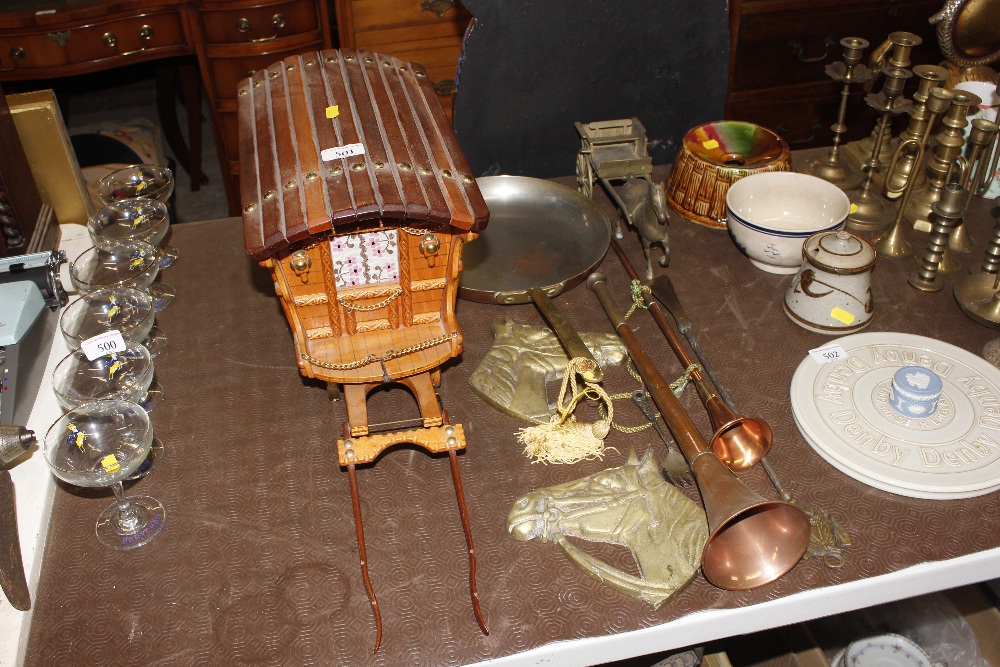 A wooden gypsy caravan and two brass horse plaques