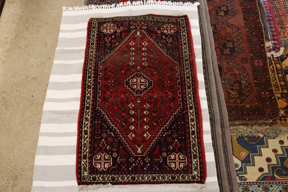 An approx. 2'1" x 3'4" red and blue pattern rug