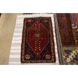 An approx. 2'1" x 3'4" red and blue pattern rug