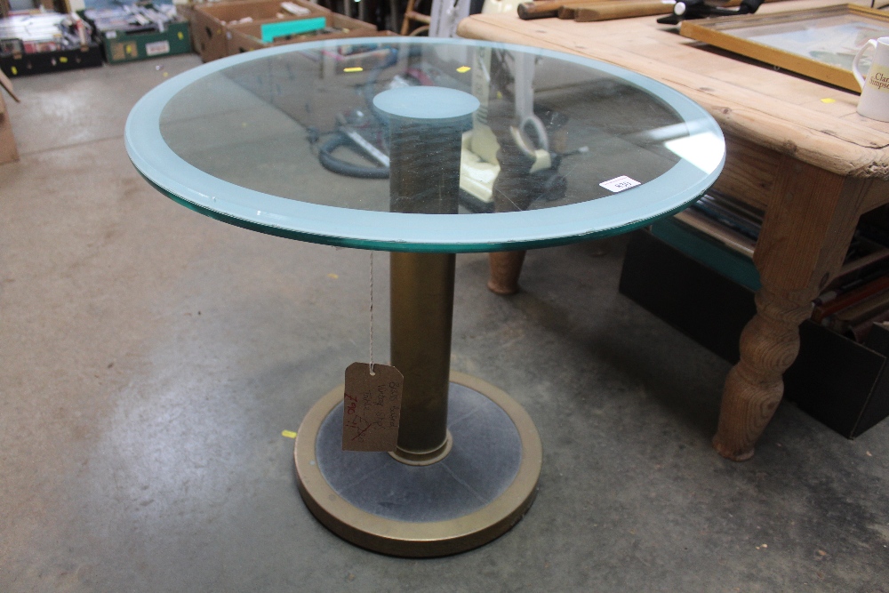 A circular brass based and glassed topped table