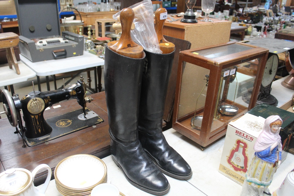 A pair of leather riding boots and wooden boot tre