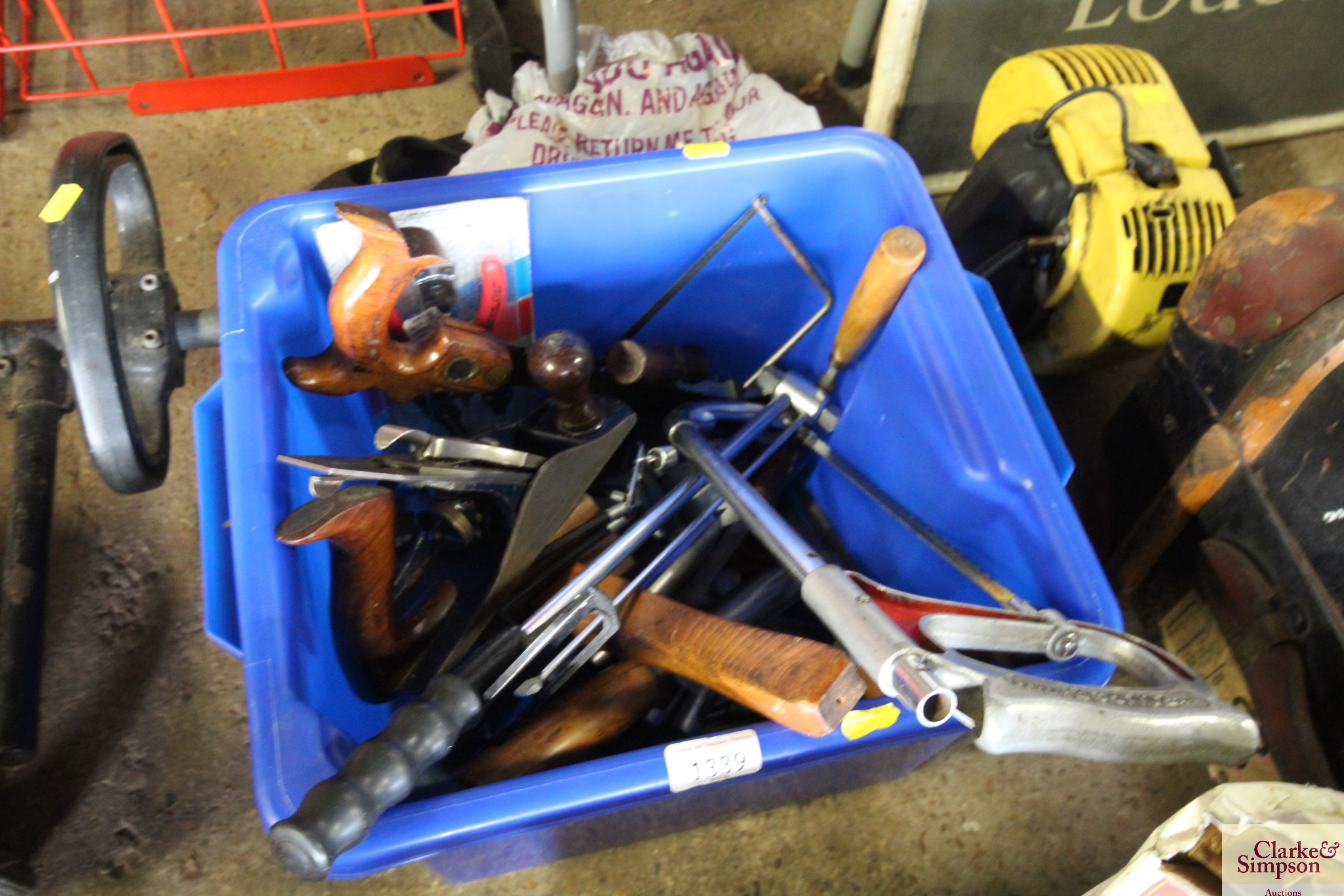 A plastic box containing various hand saws; a Reco