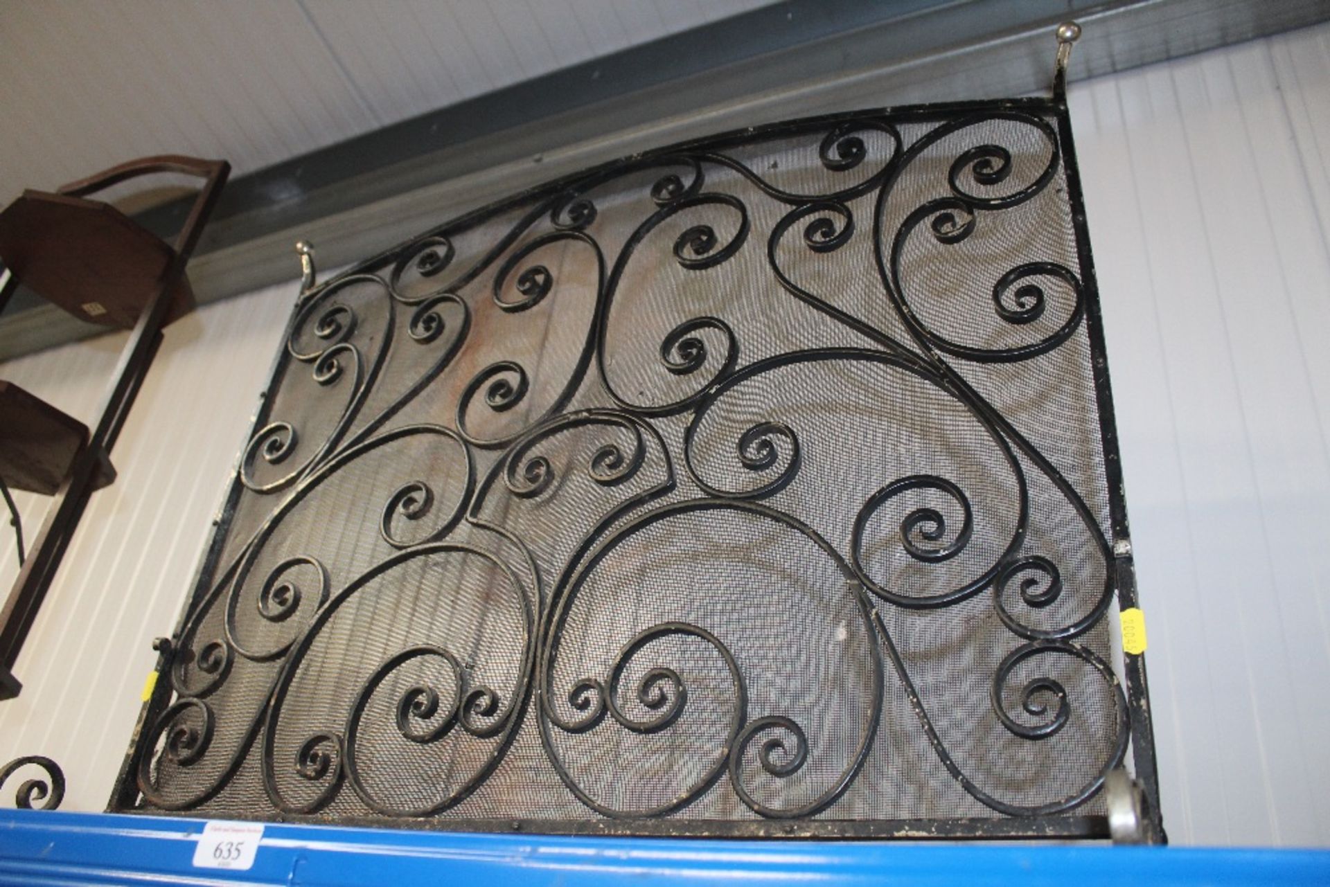 A wrought iron fire screen