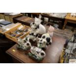 Five pig ornaments and a Staffordshire style cat w