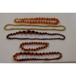 A collection of amber coloured bead necklaces