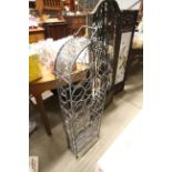 A metal wine rack with arch top
