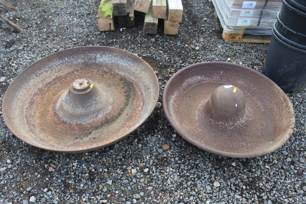 Two circular cast iron pig troughs