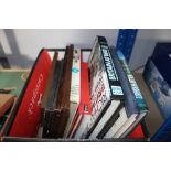 A box of various books and framed cigarette cards