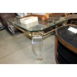 An ornate brass and clear Perspex coffee table wit