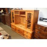 A continental pine and glazed entertainment unit