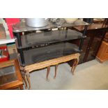A metal and glass three tier television stand and