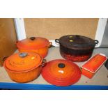 Three Le Creuset cooking dishes with covers, one e