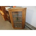 A stripped pine and leaded glazed corner cabinet