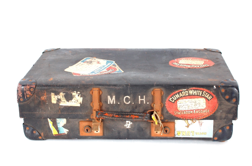 A Revelation suitcase bearing various labels inclu