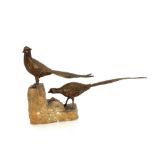 A pair of bronzed pheasants raised on rockwork bas