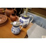 Two Willow pattern milk jugs with pewter lids