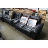 A pair of black upholstered two seater sofas