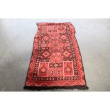 An approx. 5'10" x 2'3" red patterned rug