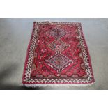 An approx. 5' x 3'6" red patterned rug