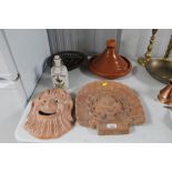 Two terracotta wall plaques together with a pot an