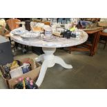 A round dining table raised on tripod base