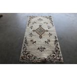 An approx. 6'2" x 3'1" cream patterned rug